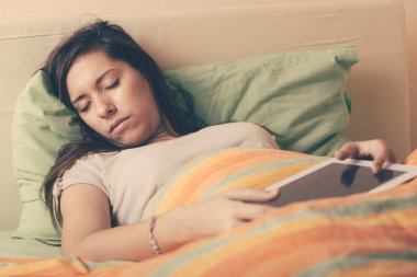 Genç kadın Falling uykuda kullanarak dijital Tablet yatakta iken