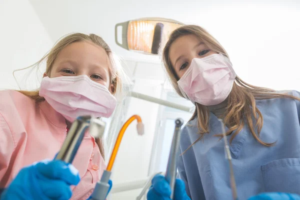 Pequenos dentistas femininos segurando ferramentas dentárias olhando para a câmera . — Fotografia de Stock