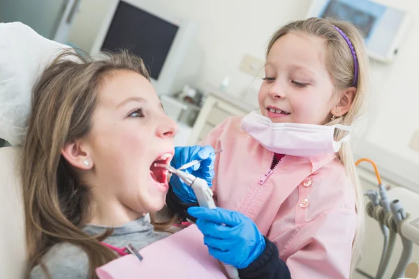 Pequenas meninas dentista e paciente durante o exame dentário . — Fotografia de Stock