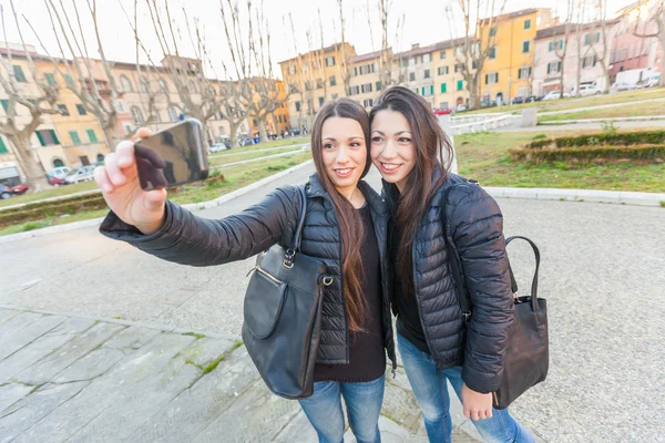 Kobiece bliźniaczki biorąc Selfie w mieście. — Zdjęcie stockowe