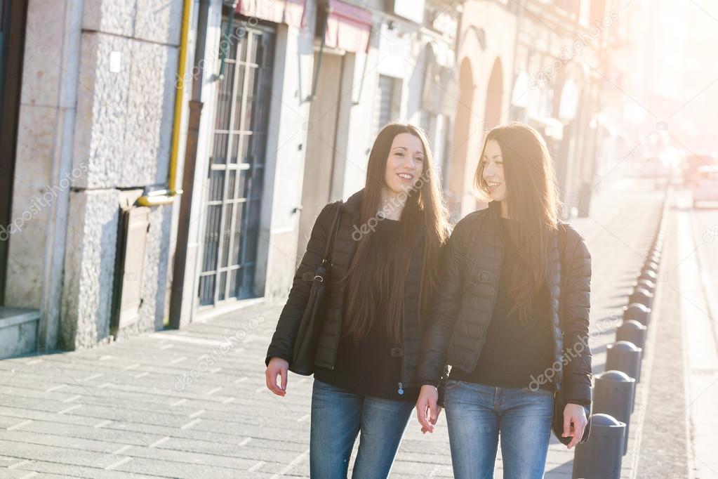 Female Twins Walking on Sidewalk in the City