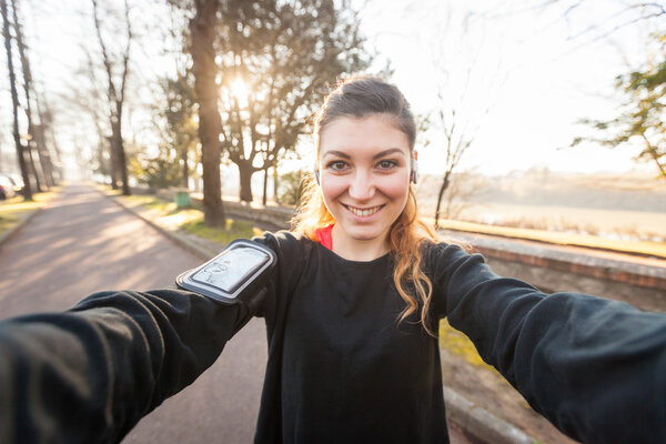 Молодая спортивная женщина делает селфи в парке
