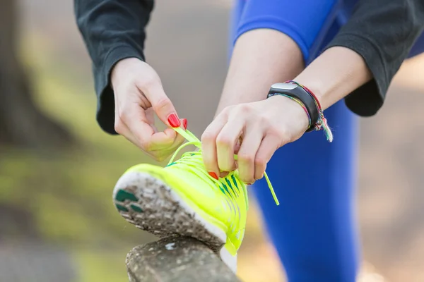 Młodzi sportowcy kobieta robi się jej buty przed uruchomieniem. — Zdjęcie stockowe