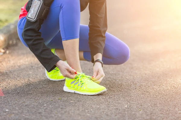 Joven mujer deportiva haciendo sus zapatos antes de correr . — Foto de Stock