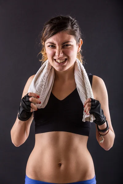 Sporty giovane donna macinare denti su sfondo nero . — Foto Stock