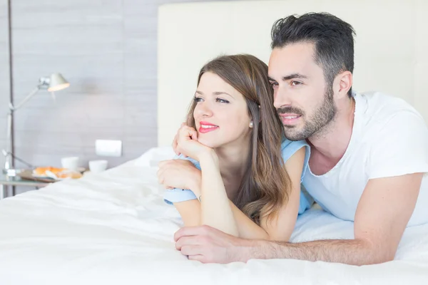 Jovem casal abraçado na cama — Fotografia de Stock