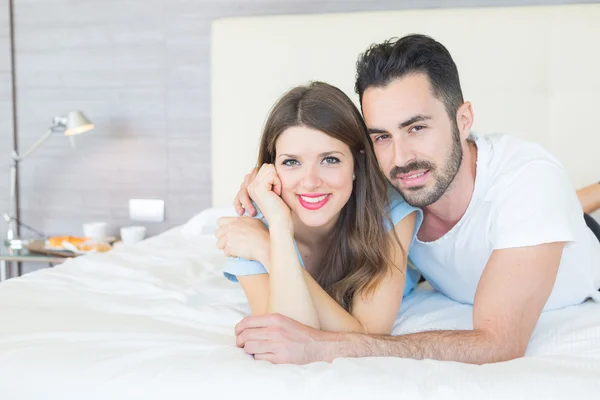 Jeune couple embrassé sur le lit — Photo