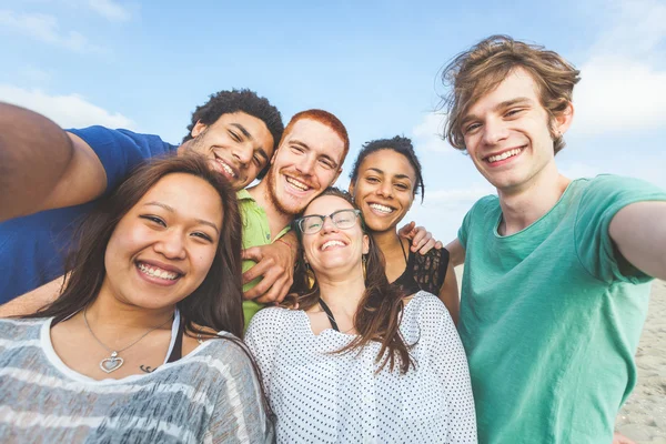 Multiracial grupp av vänner med Selfie på stranden — Stockfoto