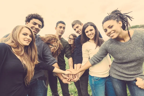 Grupo multirracial de amigos com as mãos na pilha — Fotografia de Stock