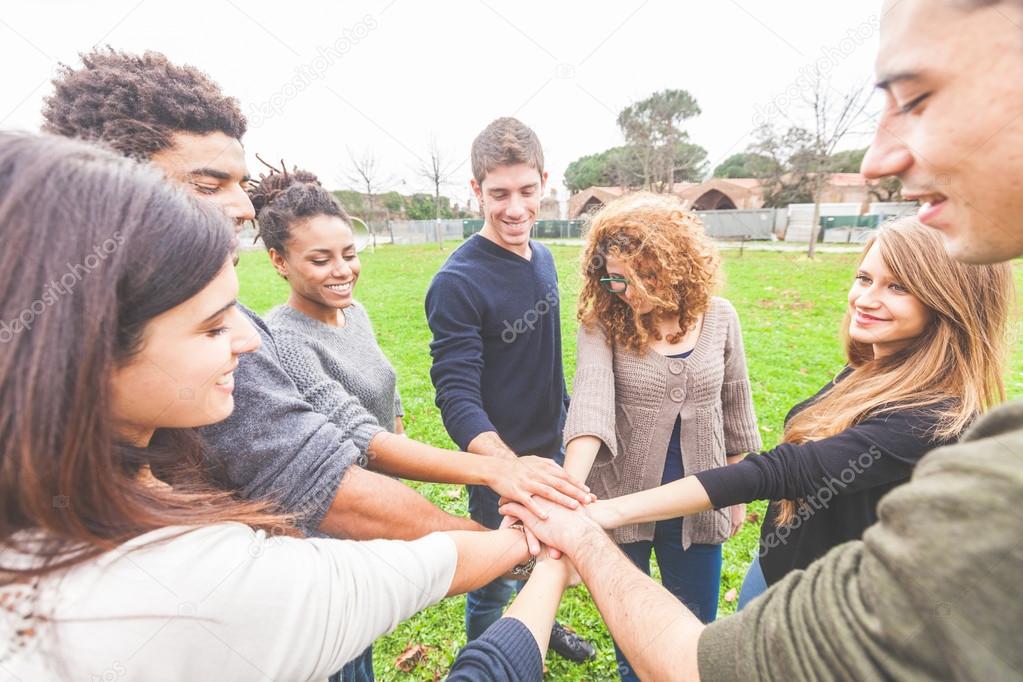 Multiracial group of friends with hands in stack