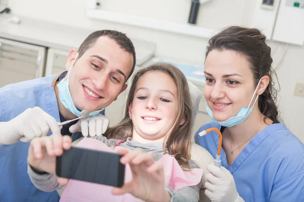 Paciente feliz, dentista e assistente tomando selfie todos juntos — Fotografia de Stock