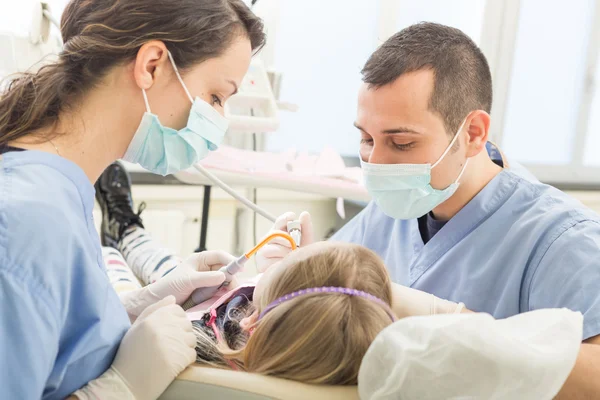 Dentista e Assistente de Odontologia examinando dentes Young Girl — Fotografia de Stock