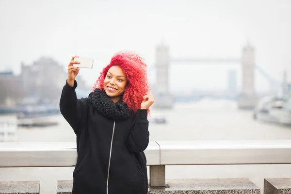 Menina tirando selfie em Londres com Tower Bridge no fundo — Fotografia de Stock