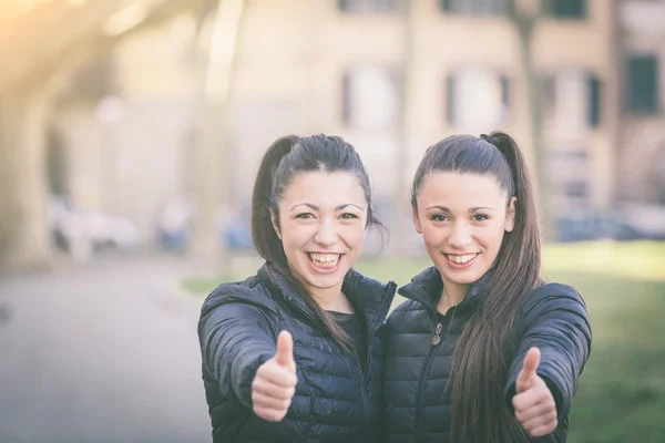 幸せな女性は、公園を示す親指を双子します。 — ストック写真