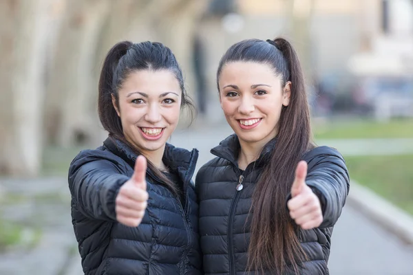 Gelukkige vrouw twins weergegeven: duimen omhoog in het park — Stockfoto