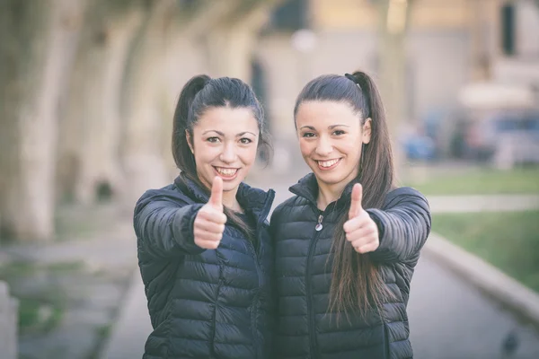 Gelukkige vrouw twins weergegeven: duimen omhoog in het park — Stockfoto