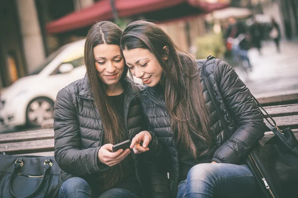 Dwóch bliźniaków kobieta patrząc w inteligentny telefon — Zdjęcie stockowe