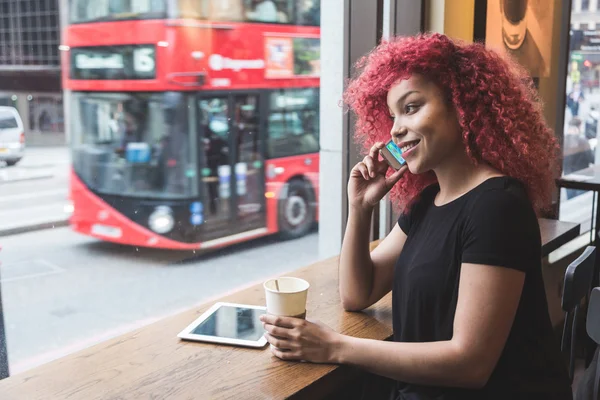 Schönes Mädchen in einem Café, das auf dem Smartphone spricht — Stockfoto