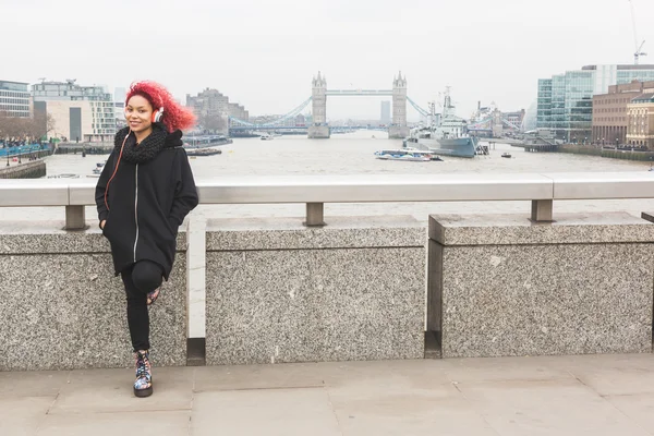 Vacker kvinna lyssnar musik i London — Stockfoto