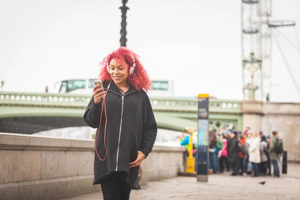 Vacker kvinna lyssnar musik i London — Stockfoto