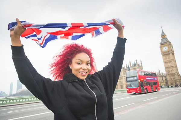 Belle femme rousse tenant le drapeau du Royaume-Uni à Londres — Photo