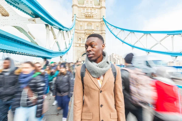 Muž na Tower Bridge, Londýn, s rozmazané lidí na pozadí — Stock fotografie