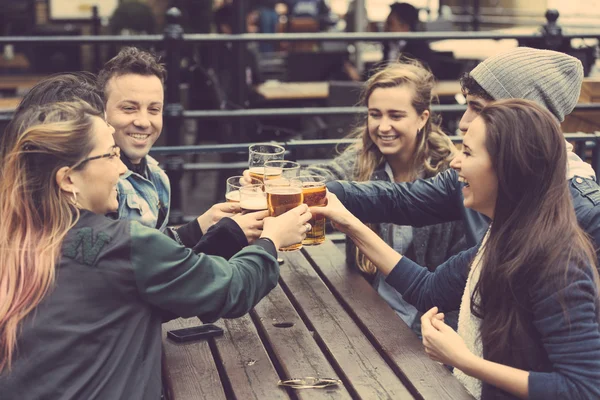 群的朋友享受一杯啤酒一家在伦敦的酒吧 — 图库照片