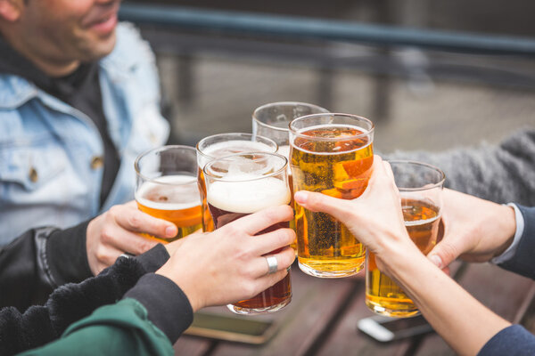 Группа друзей, наслаждающихся пивом в пабе в Лондоне

