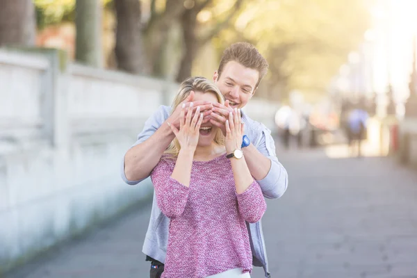 Young man making a surprise to a girl — Stock Photo, Image