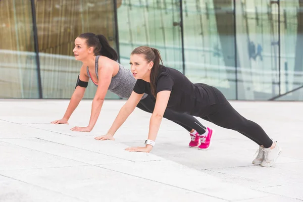 Duas mulheres fazendo exercícios push-ups — Fotografia de Stock