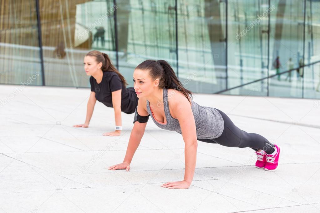 Two women doing push-ups exercises