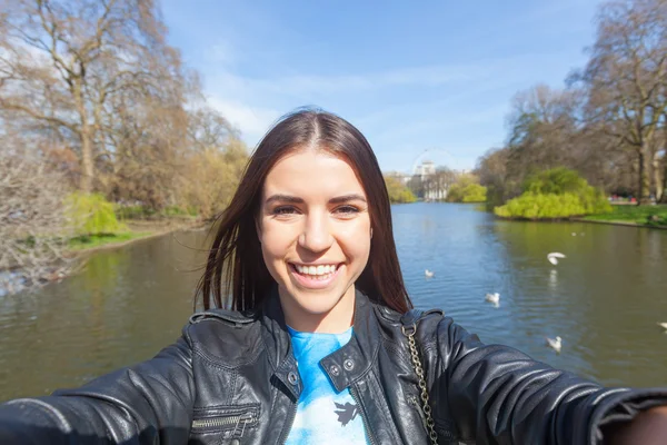 Ung kvinna med en selfie på park i London — Stockfoto