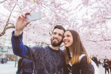 Kiraz çiçekleri ile Stockholm'de bir selfie alarak hipster Çift