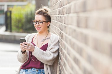 Londra'nın akıllı telefon yazarak hipster kadın.