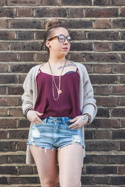 Hipster mujer retrato contra una pared de ladrillo en Londres . — Foto de Stock