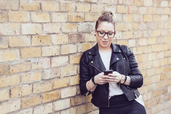 Hipster vrouw te typen op slimme telefoon in Londen. — Stockfoto