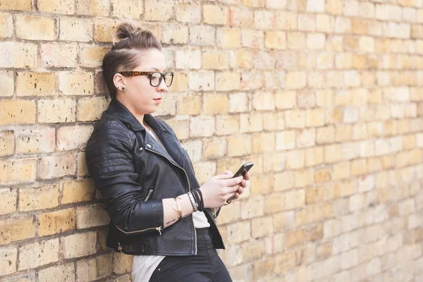 Hipster-Frau tippt in London auf Smartphone. — Stockfoto