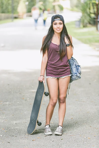 Retrato de una hermosa chica patinadora en el parque . —  Fotos de Stock