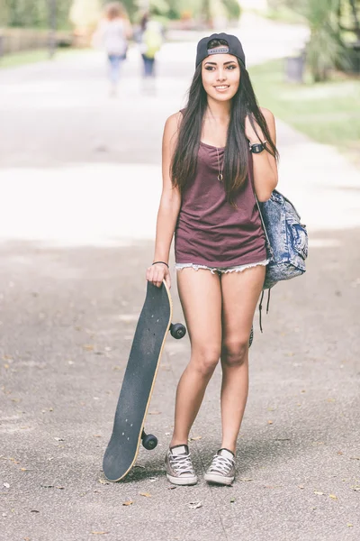 Retrato de uma linda garota patinadora no parque . — Fotografia de Stock