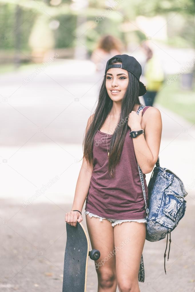 Portrait of a beautiful skater girl at park.