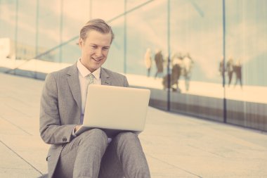 Moda genç adam ile dizüstü bilgisayar açık çalışma