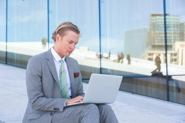 Joven hombre de moda trabajando con el ordenador portátil al aire libre — Foto de Stock