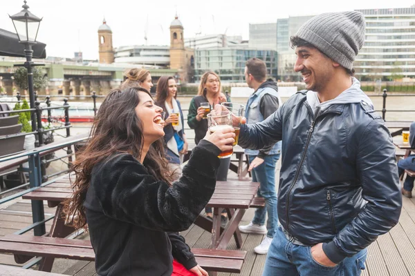 Jovem casal desfrutando de uma cerveja no pub — Fotografia de Stock