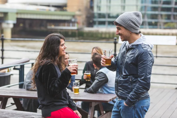 Junges Paar genießt ein Bier in der Kneipe — Stockfoto