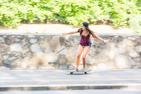 Hermosa chica de raza mixta patinaje en la ciudad, panorámica —  Fotos de Stock