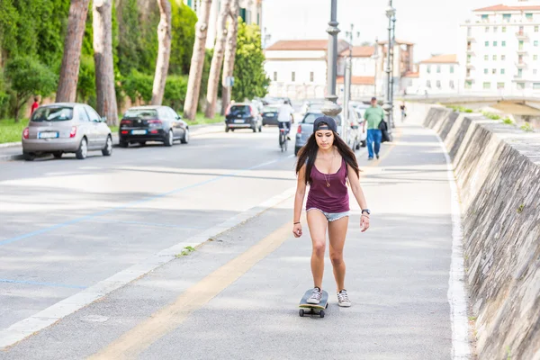 Hermosa chica de raza mixta patinaje en la ciudad — Foto de Stock