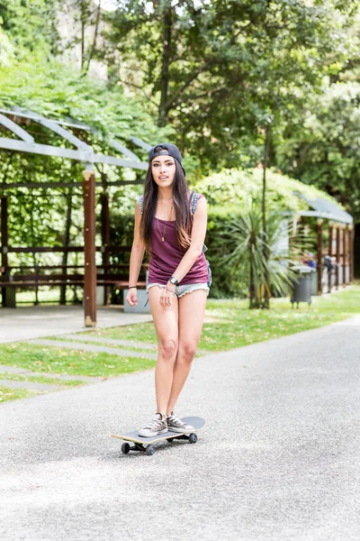 Linda corrida mista menina patinação no parque — Fotografia de Stock