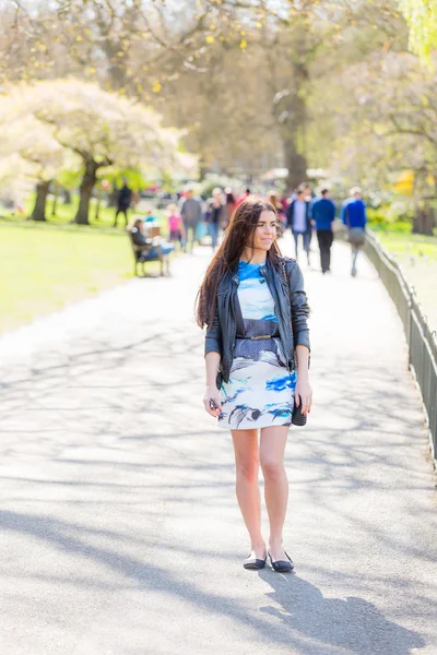 Junge Frau spaziert durch Park in London — Stockfoto