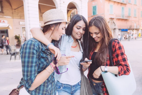 Three young women with smart phone in the city — Stock Photo, Image