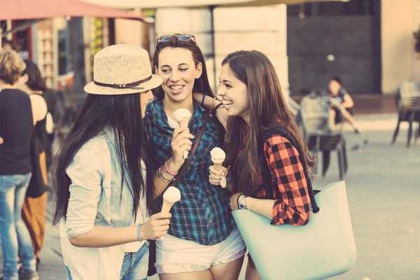 Three happy women eating ice cream in the city — Stock Photo, Image